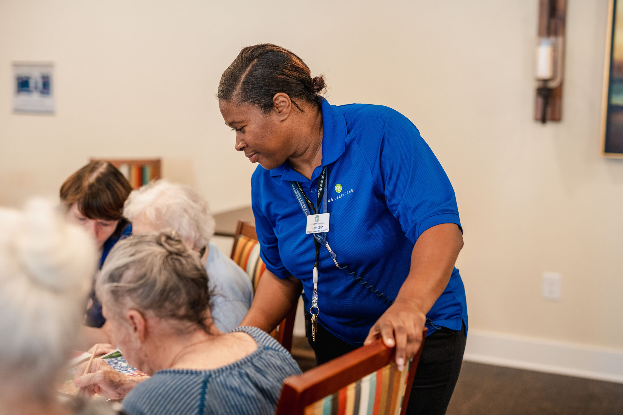 The Claiborne at Newnan Lakes employee helping senior resident during activity